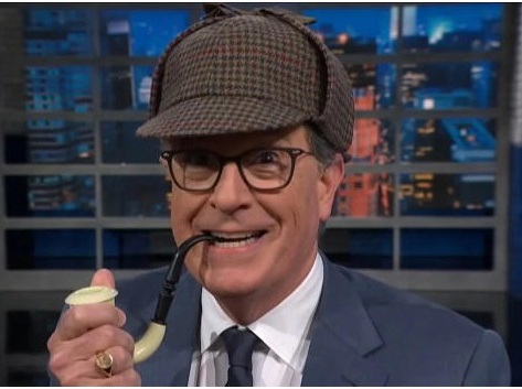 Stephen Colbert wearing a deerstalker and holding a pipe.